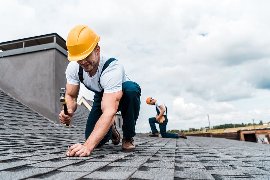 Roofer repairing asphalt shingles